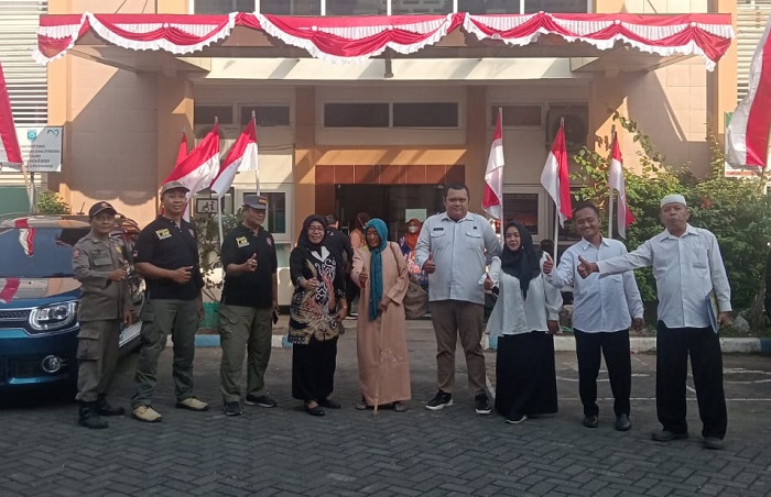 Bagong Munaji, Staf Pelaksana Harian Dinsos Kabupaten Probolinggo, menyerahkan perempuan paruh baya kepada Endi Supriadi, Kepala Desa Kedungrejo, di halaman Kantor Dinsos Kabupaten Probolinggo. (Dok. Dinsos Kabupaten Probolinggo)