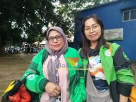 Dua ojol wanita yang membagikan bunga kepada massa aksi yang mengikuti Solidaritas Mimbar Bebas dan Doa Bersama Di Alun-Alun Kota Malang. (blok-a.com/Yogga Ardiawan)
