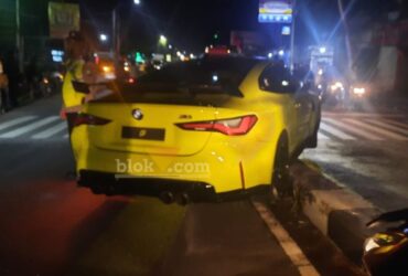Mobil sport mewah, BMW M4 Coupe berwarna kuning yang diduga milik Wakil Bupati Blitar, Beky Herdihansah nyangsang di pembatas jalan di perempatan Kanigoro. (blok-a.com/Fajar)