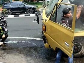 Anggota Satlantas Gresik membantu sebuah truk bermuatan keramik yang tiba-tiba mengeluarkan asap putih di depan Pos 120.(istimewa)