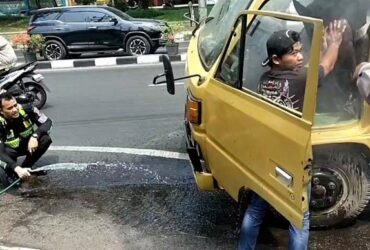 Anggota Satlantas Gresik membantu sebuah truk bermuatan keramik yang tiba-tiba mengeluarkan asap putih di depan Pos 120.(istimewa)