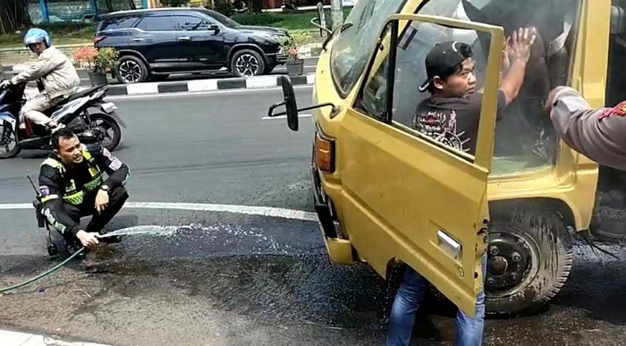 Anggota Satlantas Gresik membantu sebuah truk bermuatan keramik yang tiba-tiba mengeluarkan asap putih di depan Pos 120.(istimewa)