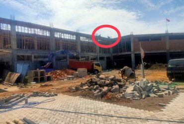 Tampak dua pekerja tanpa mengenakan APD lengkap berada diatas gedung proyek Puskesmas Panekan.