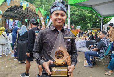 Amar Maruf Stya Bakti, saat memamerkan piala juara 1 lomba logo pariwisata kebudayaan Kabupaten Malang (blok-a.com / Yogga Ardiawan)