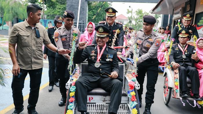 Kapolres Jombang saat mengayuh becak untuk melepas anggota yang purna tugas.(blok-a.com/Syahrul Wijaya)