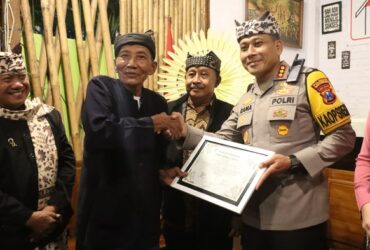 Kapolresta Banyuwangi bersama Ibu Bhayangkari Ny. dr. Novana Oktavia Mantiri Rama Samtama Putra saat menerima anugerah Warga Kehormatan Suku Osing, Selasa malam (23/12/2025). (Istimewa)