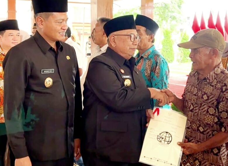 Bupati Blitar, Drs. H. Rijanto, MM., didampingi Wakil Bupati H. Beky Herdihansah menyerahkan secara simbolis sertifikat redistribusi tanah PPTPKH kepada masyarakat. (blok-a.com/Fajar)