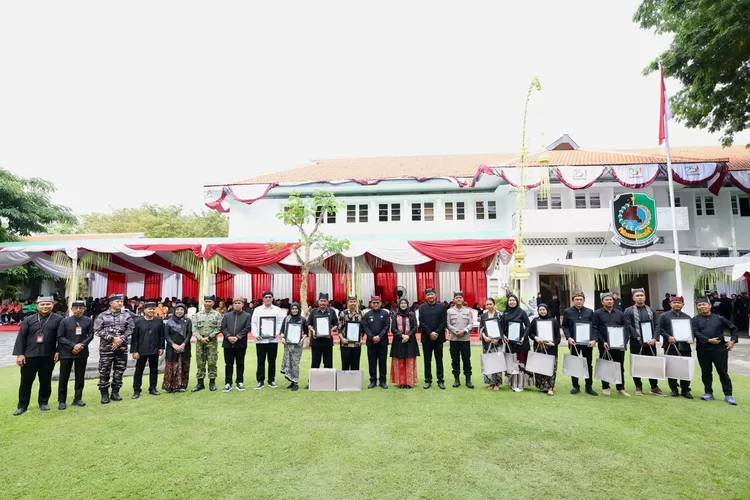Momen peringatan Harjaba ke-254, Bupati Banyuwangi Ipuk Fiestiandani berfoto bersama warga dan lembaga penerima penghargaan di halaman Kantor Bupati Banyuwangi, Kamis (18/12/2025).