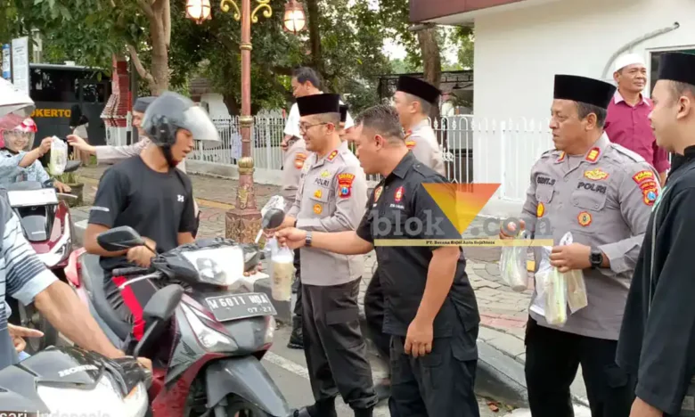 Teks: Kapolres Mojokerto AKBP Andi Yudha Pranata (tengah: memakai baju dinas dan berpeci) saat membagikan takjil kepada para pengguna jalan di depan rumah dinas di jalan Pahlawan Kota Mojokerto.(blue k-a.com/Syahrul Wijaya)