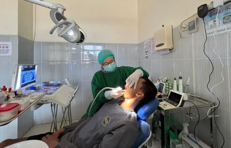 Dokter Gigi Spesialis Konservasi Gigi RSUD Genteng, drg. Ceples Dian Kartika Wisnu Putri, Sp.KG, saat melakukan pemeriksaan gigi pasien, Rabu (11/2/2026)(blok-a.com/Kuryanto)