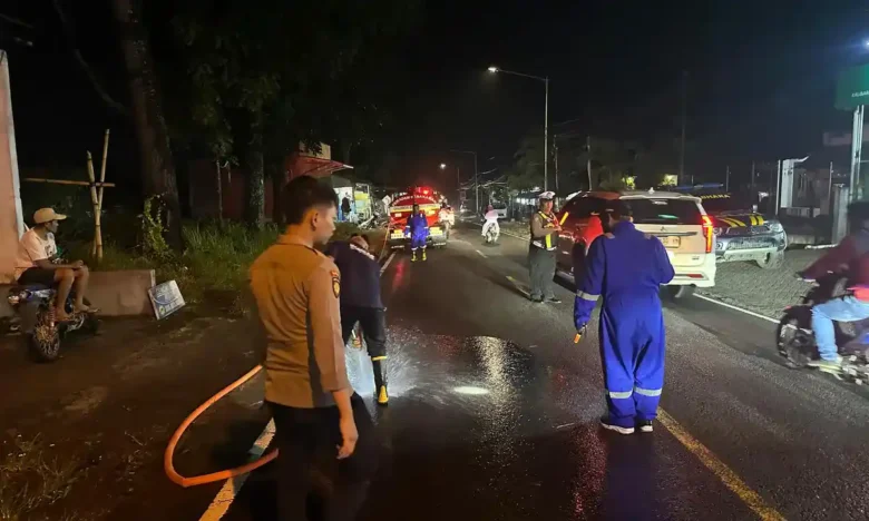 Unit Lantas Polsek Kalibaru yang dipimpin Aipda Aries Prasetiyanto bersama anggota saat membersihkan tumpahan solar di Jalur Provinsi Jember-Banyuwangi, tepat di depan Kantor Balai Desa Kalibaru Kulon, Rabu (11/2/2026) sore