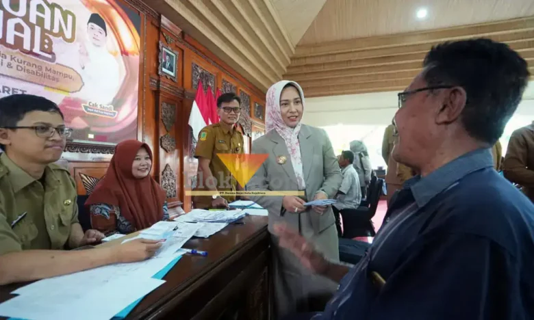 Wali kota Mojokerto Ika Puspita Sari sedang menyalurkan bantuan sosial kepada tukang becak (foto: Blok-a.com/Syahrul Wijaya)