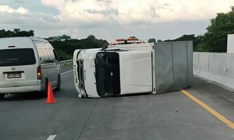 Mobil boks Isuzu Traga yang terguling di ruas tol SuMo.(Foto: Dokumen PJR 3 Polda Jatim)