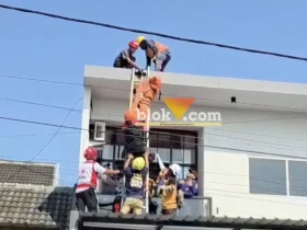 Proses evakuasi korban tersengat listrik di atas atap rumah tingkat.(blok-a.com/Syahrul Wijaya)
