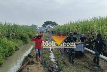 Prajurit Kodim 0815 Mojokerto nampak gotong royong dengan warga mengusung material batu untuk pembangunan jembatan.(blok-a.com/Syahrul Wijaya)