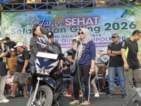 Teks: Pemenang hadiah utama berupa satu unit sepeda motor Honda Beat nampak bergembira diatas panggung.(blok-a.com/Syahrul Wijaya)