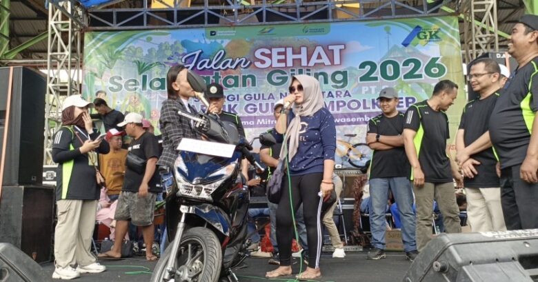 Teks: Pemenang hadiah utama berupa satu unit sepeda motor Honda Beat nampak bergembira diatas panggung.(blok-a.com/Syahrul Wijaya)