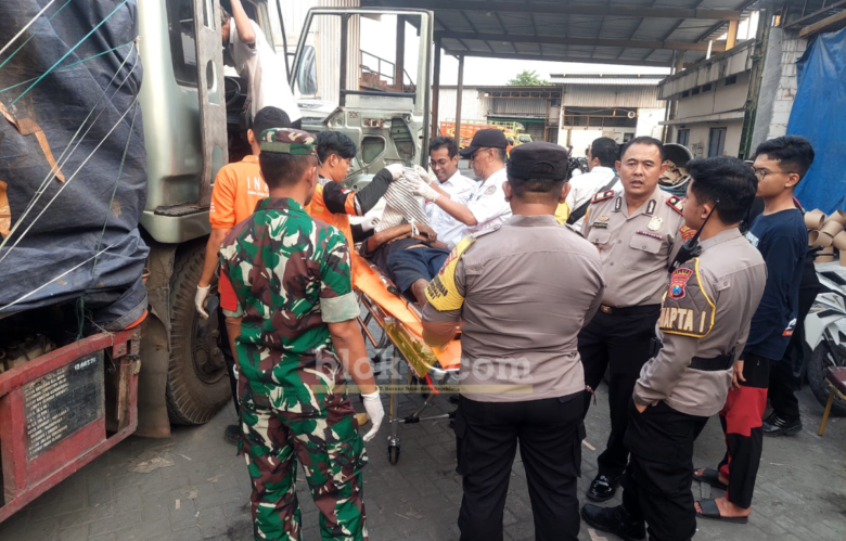 Petugas sedang mengevakuasi korban yang meninggal mendadak di kabin truk (foto: Blok-a.com/Syahrul Wijaya)