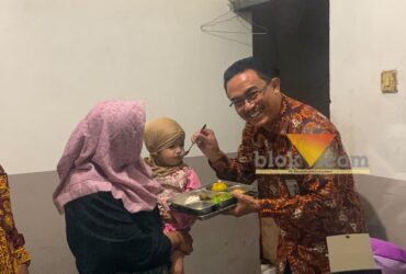 Kepala Perwakilan Kemendukbangga/BKKBN Provinsi Jawa Timur, Shodiqin saat menyuapi putri dari penerima manfaat, Siti Badriah (blok-a.com / Yogga Ardiawan)