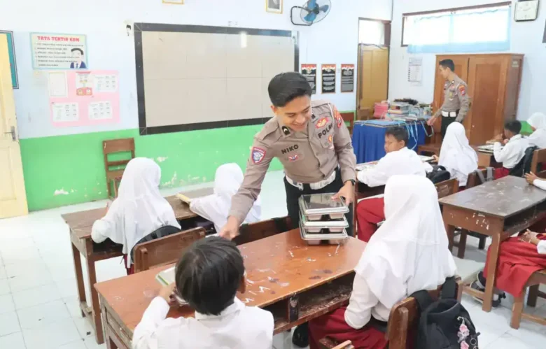 Anggota polres magetan saat membagikan menu mbg di salah satu sekolah dasar (foto: istimewa)