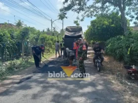 Babinsa Koramil 0825/09 Tegaldlimo saat memonitor dan membantu warga memperbaiki jalan Desa Kedunggebang, Kecamatan Tegaldlimo, Senin (13/07/2026)(foto: Blok-a.com/Kuryanto)