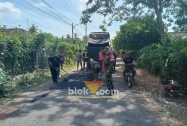 Babinsa Koramil 0825/09 Tegaldlimo saat memonitor dan membantu warga memperbaiki jalan Desa Kedunggebang, Kecamatan Tegaldlimo, Senin (13/07/2026)(foto: Blok-a.com/Kuryanto)