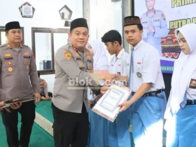 Kapolres Jombang AKBP Ardi Kurniawan menyerahkan bantuan beasiswa kepada putra-putri anggota berprestasi (foto: Blok-a.com/Syahrul Wijaya)
