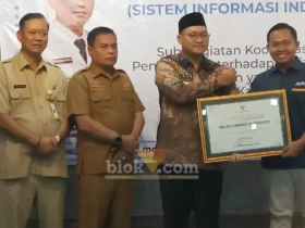 Kepala Perum BULOG Kantor Cabang Mojokerto, Muhammad Husin saat menerima penghargaan yang diserahkan oleh Wakil Bupati Mojokerto (foto: Blok-a.com/Syahrul Wijaya)