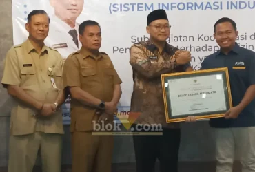 Kepala Perum BULOG Kantor Cabang Mojokerto, Muhammad Husin saat menerima penghargaan yang diserahkan oleh Wakil Bupati Mojokerto (foto: Blok-a.com/Syahrul Wijaya)