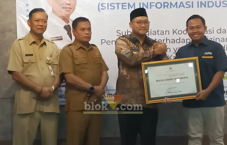 Kepala Perum BULOG Kantor Cabang Mojokerto, Muhammad Husin saat menerima penghargaan yang diserahkan oleh Wakil Bupati Mojokerto (foto: Blok-a.com/Syahrul Wijaya)