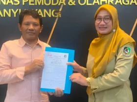 Ketua Pengurus Kabupaten (Pengkab) PSOI, H.M. Zaenul Arifin bersama Kadispora, Dwi Handayani usai melakukan penandatanganan PKS pelaksanaan Gandrung Surf Competition 2026. (foto: istimewa)