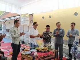 Sekda Kabupaten Mojokerto, Teguh Gunarko menyerahkan potongan tumpeng kepada Kades Mojojajar Sya'roni (foto: Blok-a.com/Syahrul Wijaya)