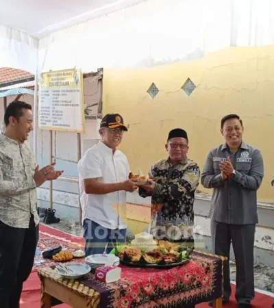 Sekda Kabupaten Mojokerto, Teguh Gunarko menyerahkan potongan tumpeng kepada Kades Mojojajar Sya'roni (foto: Blok-a.com/Syahrul Wijaya)