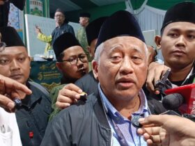 teks:%C2%A0Prof.%20Dr.%20KH.%20Moh.%20Nuh%20usai%20pimpin%20pleno%20IV.(blok-a.com/Syahrul%20Wijaya)%0A%0AJudul:%20Voting%20Muktamar%20NU%20Ubah%20Mekanisme%20Pemilihan%20Ketum%20PBNU,%20Opsi%20AHWA%20Menang%20Telak%0A%0AJombang,%20blok-a.com%20%E2%80%93%20Mekanisme%20pemilihan%20Ketua%20Umum%20Pengurus%20Besar%20Nahdlatul%20Ulama%20(PBNU)%20dalam%20Muktamar%20ke-35%20NU%20resmi%20berubah.%20Melalui%20voting%20yang%20berlangsung%20hingga%20Minggu%20(30/8/2026)%20dini%20hari,%20mayoritas%20peserta%20Muktamar%20memilih%20Opsi%20B,%20yakni%20perubahan%20mekanisme%20pemilihan%20Ketua%20Umum%20PBNU.%0A%0AHasil%20voting%20menunjukkan%20sebanyak%20401%20peserta%20menyetujui%20perubahan%20mekanisme%20pemilihan.%20Sementara%20itu,%20150%20peserta%20memilih%20mempertahankan%20mekanisme%20lama%20dan%20satu%20suara%20dinyatakan%20tidak%20sah.%0A%0AHasil%20tersebut%20disampaikan%20Prof%20Dr%20KH%20Mohammad%20Nuh%20selaku%20Organizing%20Committee%20(OC)%20Muktamar%20ke-35%20NU%20sekitar%20pukul%2000.50%20WIB.%0A%0AMenurut%20M%20Nuh,%20voting%20dilakukan%20setelah%20pembahasan%20di%20Komisi%20Organisasi%20belum%20menemukan%20titik%20temu%20antara%20mekanisme%20pemilihan%20langsung%20dengan%20sistem%20one%20man%20one%20vote%20dan%20mekanisme%20Ahlul%20Halli%20wal%20Aqdi%20(AHWA).%0A%0A%E2%80%9C401%20menyetujui%20untuk%20dilakukan%20perubahan%20mekanisme%20pemilihan%20ketua%20umum,%20150%20berkeinginan%20tetap,%20dan%20satu%20suara%20tidak%20sah,%E2%80%9D%20kata%20M%20Nuh.%0A%0ADengan%20hasil%20tersebut,%20Muktamar%20ke-35%20NU%20menyepakati%20perubahan%20mekanisme%20pemilihan%20Ketua%20Umum%20PBNU.%20Sistem%20baru%20akan%20memberikan%20ruang%20kepada%20PWNU,%20PCNU,%20dan%20PCINU%20untuk%20mengusulkan%20nama%20calon,%20sebelum%20proses%20selanjutnya%20melibatkan%20Rais%20Aam%20dan%20AHWA.%0A%0ADalam%20draf%20Opsi%20B%20yang%20dipilih%20mayoritas%20peserta,%20setiap%20Pengurus%20Wilayah%20Nahdlatul%20Ulama%20(PWNU),%20Pengurus%20Cabang%20Nahdlatul%20Ulama%20(PCNU),%20maupun%20Pengurus%20Cabang%20Istimewa%20Nahdlatul%20Ulama%20(PCINU)%20diberi%20kesempatan%20mengusulkan%20maksimal%20lima%20nama%20calon%20Ketua%20Umum%20PBNU.%0A%0ASeluruh%20nama%20yang%20diusulkan%20kemudian%20ditabulasi%20untuk%20mendapatkan%20lima%20calon%20dengan%20jumlah%20dukungan%20terbanyak.%0A%0ALima%20nama%20tersebut%20selanjutnya%20disampaikan%20kepada%20Rais%20Aam%20terpilih%20untuk%20mendapatkan%20persetujuan.%0A%0AMenurut%20M%20Nuh,%20para%20calon%20yang%20masuk%20dalam%20lima%20besar%20juga%20harus%20menyatakan%20kesediaan%20mengikuti%20ketentuan%20yang%20ditetapkan%20melalui%20pakta%20integritas.%0A%0A%E2%80%9CDari%20lima%20yang%20terbesar%20atau%20terbanyak%20tadi%20itu,%20disampaikan%20kepada%20Rais%20Aam%20terpilih%20untuk%20mendapatkan%20restu,%20dan%20dia%20harus%20janji%20untuk%20seperti%20pakta%20integritas%20seperti%20itu,%E2%80%9D%20jelas%20M%20Nuh.%0A%0ASetelah%20mendapatkan%20persetujuan%20Rais%20Aam,%20lima%20nama%20tersebut%20akan%20masuk%20dalam%20tahapan%20berikutnya%20melalui%20mekanisme%20AHWA%20untuk%20menentukan%20Ketua%20Umum%20PBNU%20periode%202026%E2%80%932031.%0A%0AM%20Nuh%20menegaskan,%20proses%20pemilihan%20Ketua%20Umum%20PBNU%20belum%20dapat%20dilakukan%20sebelum%20Rais%20Aam%20PBNU%20ditetapkan.%0A%0ATahapan%20akan%20dimulai%20dengan%20tabulasi%20usulan%20anggota%20AHWA.%20Setelah%20komposisi%20AHWA%20ditetapkan,%20para%20kiai%20yang%20tergabung%20dalam%20AHWA%20akan%20bersidang%20untuk%20menentukan%20Rais%20Aam.%0A%0A%E2%80%9CBegitu%20selesai,%20kita%20awali%20dulu%20dengan%20tabulasi%20AHWA.%20Dari%20tabulasi%20AHWA%20itu%20nanti%20segera%20AHWA%20akan%20bersidang%20atau%20bermusyawarah%20untuk%20menetapkan%20siapa%20Rais%20Aam-nya,%E2%80%9D%20katanya.%0A%0ASetelah%20Rais%20Aam%20terpilih,%20barulah%20proses%20penentuan%20Ketua%20Umum%20PBNU%20dilanjutkan%20sesuai%20mekanisme%20baru%20yang%20telah%20disepakati.%0A%0A%E2%80%9CPertama%20Rais%20Aam%20dulu,%20baru%20setelah%20Rais%20Aam%20dilanjutkan%20untuk%20Ketua%20PBNU,%E2%80%9D%20ujar%20M%20Nuh.%0A%0AMeski%20perubahan%20mekanisme%20telah%20diputuskan%20melalui%20voting,%20M%20Nuh%20mengatakan%20sejumlah%20detail%20teknis%20pelaksanaannya%20masih%20harus%20dibahas%20dalam%20sidang%20lanjutan.%0A%0APembahasan%20teknis%20tersebut%20mencakup%20tahapan%20setelah%20lima%20nama%20calon%20Ketua%20Umum%20PBNU%20diperoleh%20hingga%20proses%20penentuan%20melalui%20AHWA.%0A%0A%E2%80%9CBesok%20dengan%20hasil%20ini%20kita%20akan%20melanjutkan%20pembahasan%20lebih%20teknis%20lagi%20tentang%20mekanisme%20pemilihan%20ketua%20umum.%20Insyaallah%20besok%20pagi%20bisa%20kita%20rampungkan,%E2%80%9D%20ujarnya.%0A%0ADengan%20demikian,%20keputusan%20voting%20tersebut%20menjadi%20titik%20penting%20dalam%20Muktamar%20ke-35%20NU.%20Untuk%20pertama%20kalinya%20dalam%20rangkaian%20Muktamar%20kali%20ini,%20mayoritas%20peserta%20secara%20resmi%20memilih%20perubahan%20mekanisme%20pemilihan%20Ketua%20Umum%20PBNU%20dari%20sistem%20sebelumnya.%0A%0AM%20Nuh%20berharap%20seluruh%20rangkaian%20proses%20penentuan%20Rais%20Aam%20dan%20Ketua%20Umum%20PBNU%20dapat%20diselesaikan%20pada%20Minggu%20(30/8/2026).%0A%0AKeputusan%20tersebut%20selanjutnya%20akan%20menjadi%20dasar%20pelaksanaan%20tahapan%20pemilihan%20kepemimpinan%20PBNU%20untuk%20masa%20khidmat%202026%E2%80%932031.(Sya)