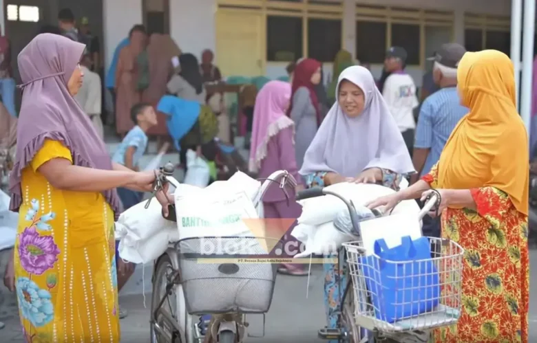 Warga masyarakat Desa Krembangan, Kecamatan Gudo, Kabupaten Jombang nampak ceria usai mendapatkan bantuan beras.(blok-a.com/Syahrul Wijaya)