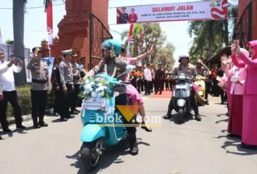 AKBP Andi Yudha Pranata beserta Istri meninggalkan Mako Polres Mojokerto dengan mengendarai Vespa, diiringi penghormatan dari jajaran personel yang melepas kepergiannya. (foto: blok-a.com/Syahrul Wijaya)