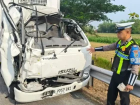 Petugas PJR 3 Polda Jatim Aipda Agus saat di lokasi dan truk boks yang hancur bagian depannya usai tabrak truk tangki.(Foto: PJR 3 Polda Jatim)