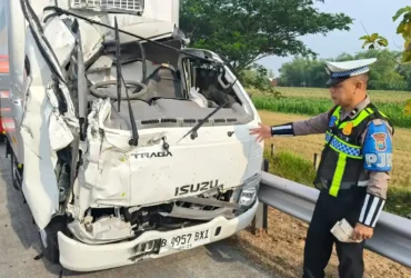 Petugas PJR 3 Polda Jatim Aipda Agus saat di lokasi dan truk boks yang hancur bagian depannya usai tabrak truk tangki.(Foto: PJR 3 Polda Jatim)