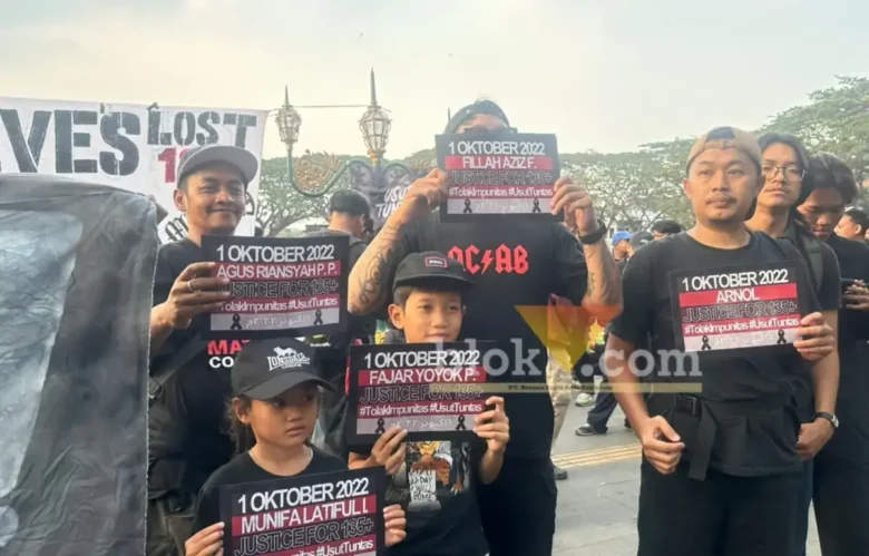 Warga Malang membawa poster tuntutan keadilan dalam peringatan empat tahun tragedi Kanjuruhan di Kota Malang, Kamis (1/10/2026). (Foto: blok-a.com / M Berril Labiq)