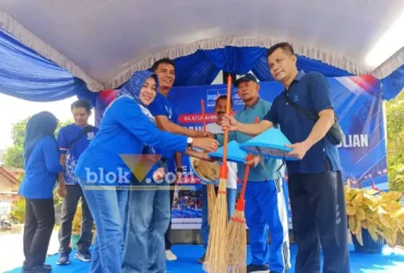 Perwakilan DPC Demokrat Magetan saat penyerahan secara simbolis caping dan sapu kepada masyarakat sekitar (foto: blok-a.com/Nanda Bagoes)